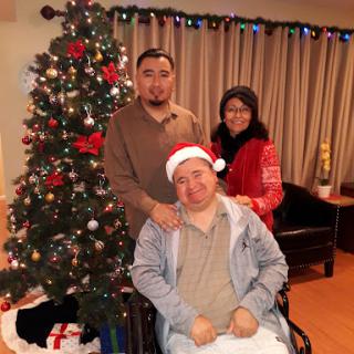 A joyful family gathering in front of a beautifully decorated Christmas tree.