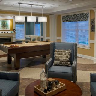 A cozy living room featuring comfortable seating and a pool table, accented with modern decor.