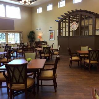 Spacious dining area with neatly arranged tables and chairs, featuring elegant interior design.