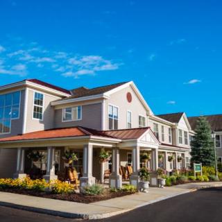 A residential building with a well-maintained garden under a clear blue sky.