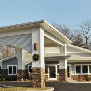 A modern building with a prominent entrance and stone accents, captured during the day.