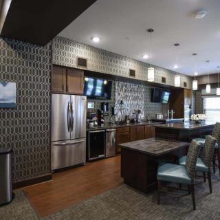 A modern kitchen interior with stainless steel appliances and stylish bar seating.