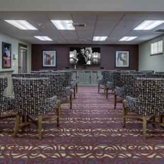 A well-arranged conference room with patterned chairs and artwork on the walls.