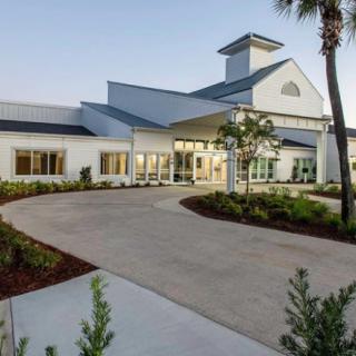 A modern building with a landscaped entrance and driveway.
