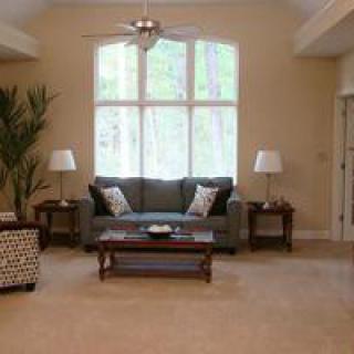 A cozy living room with a sofa, coffee table, and large window.