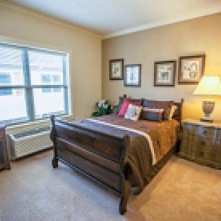 A cozy bedroom with a wooden bed, side table, and decorative elements.