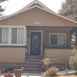 A cozy bungalow with a front porch and steps leading up to the doorway.