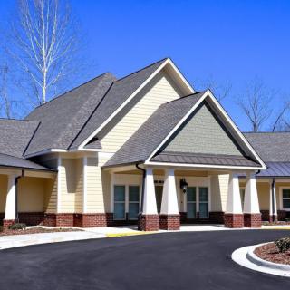 A modern residential building with a sloped roof and driveway.