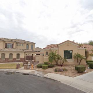 A suburban residential area featuring two houses with desert landscaping.