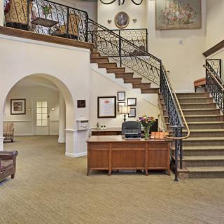 Elegant hotel lobby with a staircase and reception desk.