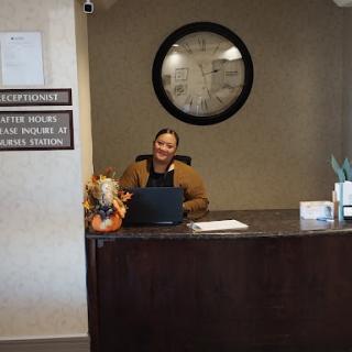 A friendly reception area with a smiling attendant at the front desk, adorned with decorative elements.