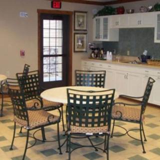 A cozy kitchen and dining area with a round table surrounded by chairs.