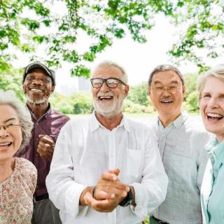 A diverse group of happy seniors enjoying a day outdoors in a park.