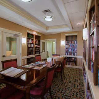 A cozy library room with elegant furnishings and an abundance of books.
