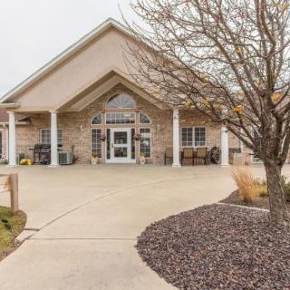 A welcoming entrance to a building with a driveway and landscaped surroundings.