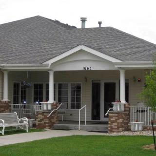 A suburban house with a front porch and well-maintained lawn.