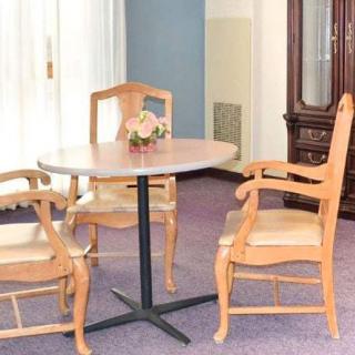 A cozy dining area with a wooden table and chairs, adorned with a small floral centerpiece.