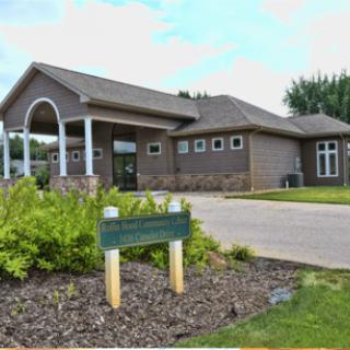 A modern building with a neatly landscaped entrance and driveway.