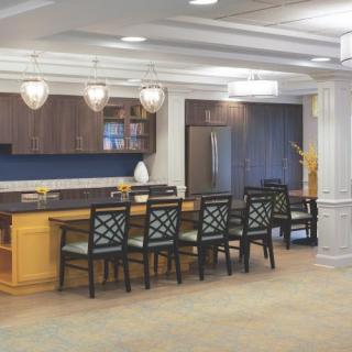 A modern kitchen interior with a bar counter and stylish seating.