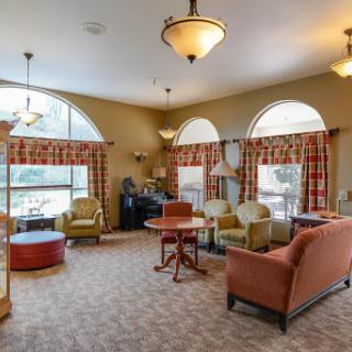 A cozy living room with comfortable seating and natural light flowing through large windows.