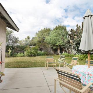 A peaceful backyard patio with outdoor furniture and a garden view.