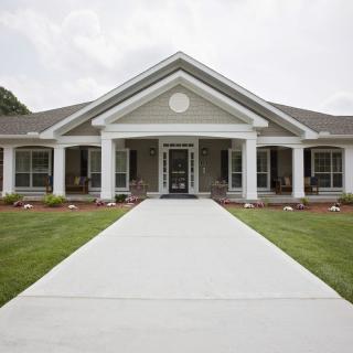 A beautiful residential home with a well-maintained front lawn and prominent columns.