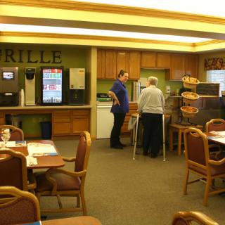 A cafeteria with a self-service food station and seating area.