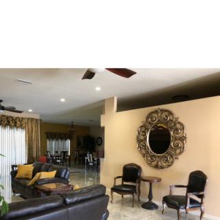 A spacious living room with elegant decor including a large ornate mirror and comfortable seating.