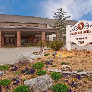 Front entrance of a hotel with signage and landscaped surroundings.