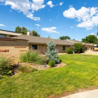A suburban house with a well-maintained lawn and clear blue sky.