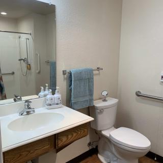 A clean and minimalistic bathroom with a sink, toilet, and mirror.
