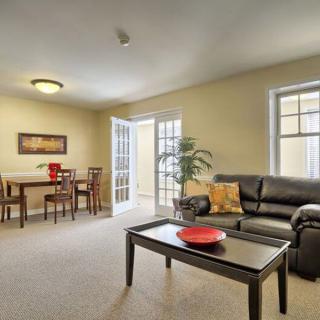 A well-lit living room with a cozy seating arrangement and a dining area.