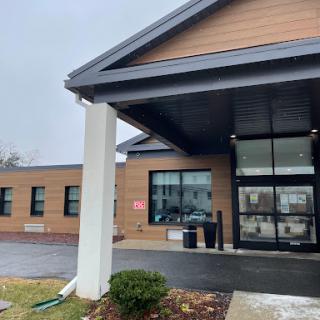 The entrance of a modern building on a cloudy day.