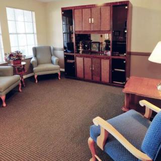 A cozy living room with comfortable armchairs and a wooden cabinet.