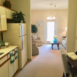 A cozy apartment with an open kitchen leading into a comfortable living room.