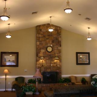 A cozy living room with a stone fireplace and comfortable seating.