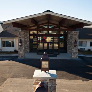 A modern building entrance with stone pillars and a broad roof.