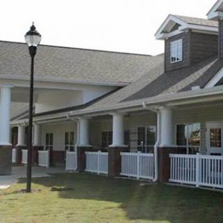 A well-structured residential building featuring a white fence and a lamp post.