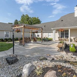 A beautifully landscaped backyard with a pergola and outdoor seating area.