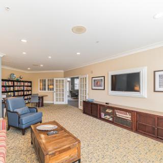 A spacious and inviting living room with comfortable seating and a bookshelf, perfect for relaxation.