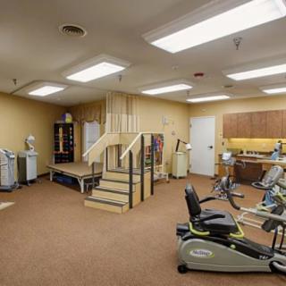 A rehabilitation room equipped with exercise machines and a staircase for physical therapy.