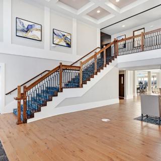 A modern and spacious interior with a wooden staircase and elegant artwork.