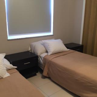 A simple bedroom with twin beds and nightstands.