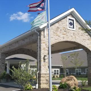 Entrance of a building with stone archway and flags on a sunny day.