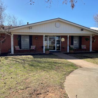 A charming residential building with a welcoming front porch on a sunny day.