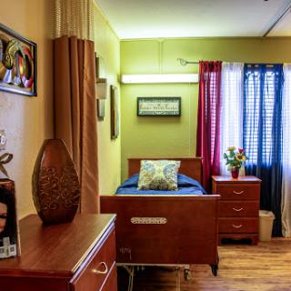 A cozy and well-decorated bedroom featuring a wooden bed, colorful curtains, and personal touches.