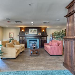 A cozy living room with sofas, a fireplace, and wooden accents.