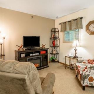 Cozy living room with television, armchair, and decorative elements.