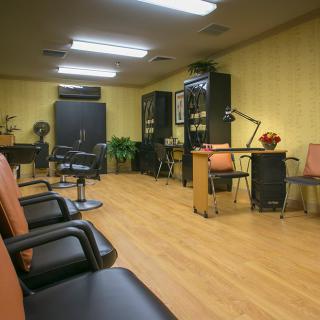 A modern hair salon interior with chairs, desks, and wooden flooring.