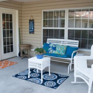 Cozy porch with wicker furniture and decorative elements.